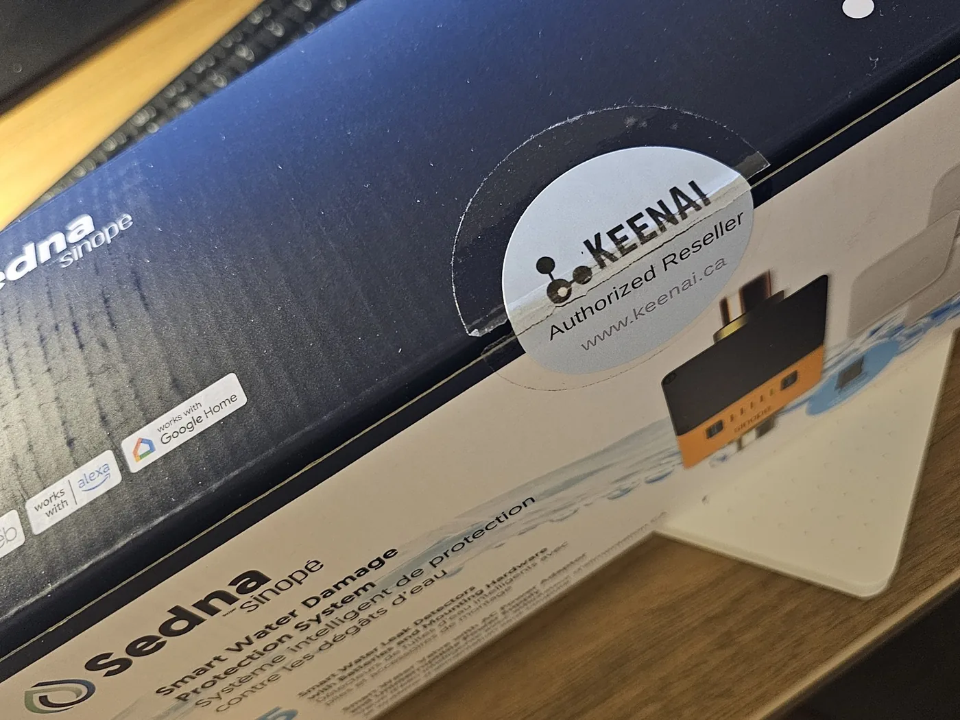 A Sinope Sedna smart water damage protection system box carrying a KeenAI Authorized Reseller sticker